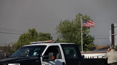 Quick pan past cops to helicopter flying over fire Stock Footage 114413629