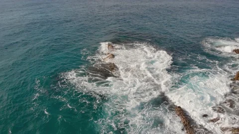 Quick pullback tilt from the rocky shore reveals the cliffs of stone Stock Footage 135588370