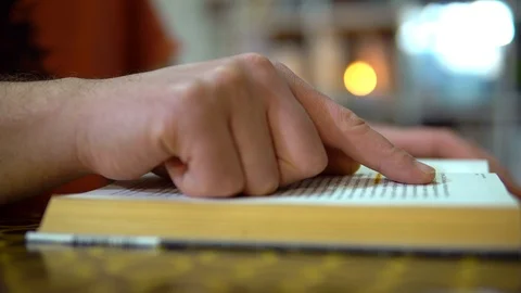 Quick read. A finger moves along the lines of a book. The guy turns the pages of Video stock 127117876