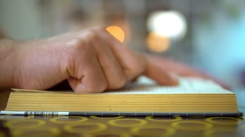 Quick read. A finger moves along the lines of a book. The guy turns the pages of Stock Footage 127350161