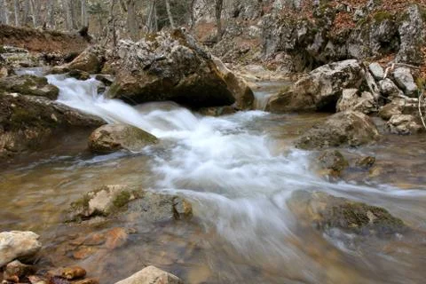 Quick run of mountain river among stones 스톡 사진