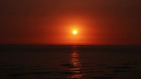 Quick shot of a beautiful sunset with the bright yellow round sun on the horizon Stock Footage 194500759