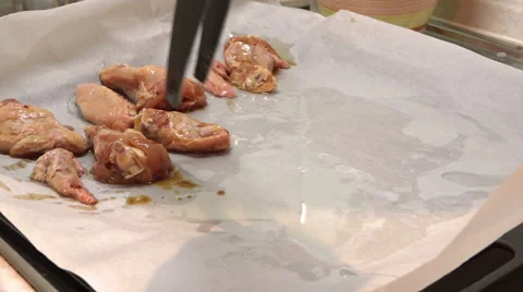 Quick Shot putting some pieces of chicken on a baking sheet Stock Footage 47326444