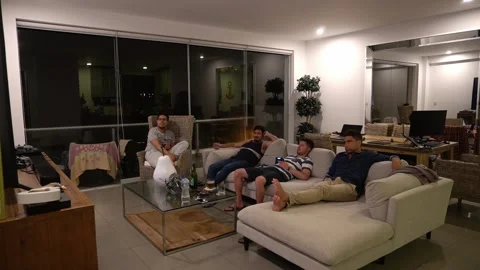Quick shot of several friends sitting in the living room drinking, playing video Stock Footage 185343736