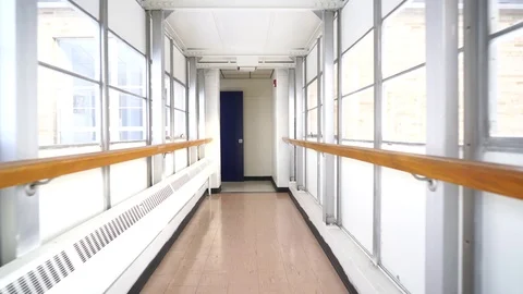 Quick stabilized walk down white glass hallway towards door Stock Footage 72232038