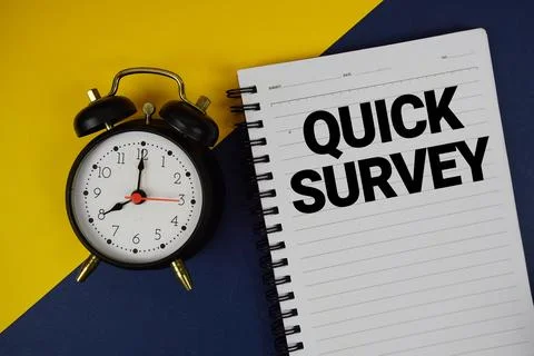 Quick Survey text written on notepad with alarm clock on blue background Stock Photos