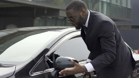Quick-tempered man noticing little scratch on his new car and getting furious Stock Footage 82044405