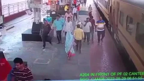 Quick-thinking cop saves man dangerously dangling from running train Stock Footage 272923270