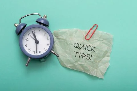 Quick Tips text on a blue background with alarm clock Stock Photos