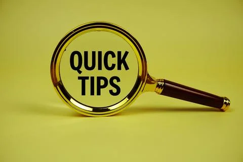 Quick Tips text with magnifying glass on yellow background Stock Photos