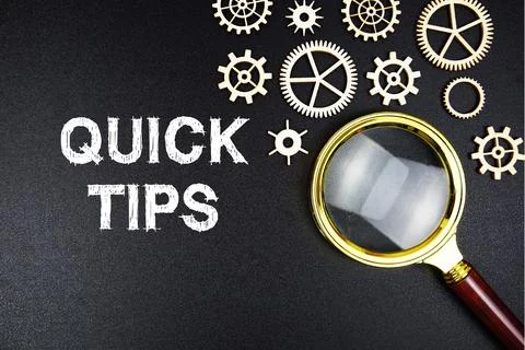 Quick Tips text message with magnifying glass on black background Stock Photos