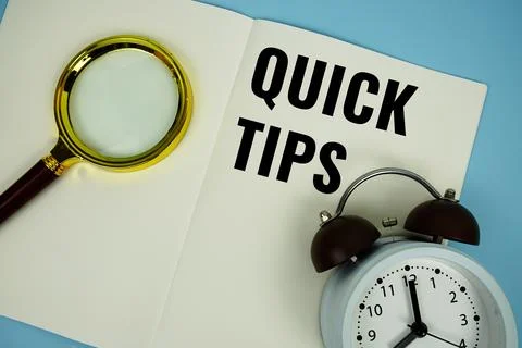 Quick Tips text message written on note page with magnifying glass and alar.. Stock Photos