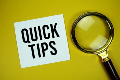Quick Tips text on paper card with magnifying glass flat lay on yellow back.. Stock Photos