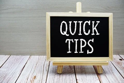 Quick Tips text written on chalkboard with easel on wooden background Stock Photos
