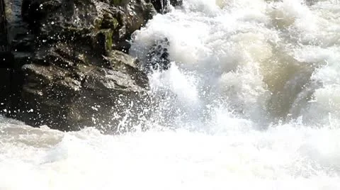 Quick water flowing past rock Stock Footage 10746314