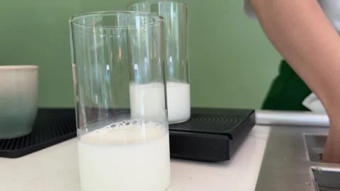 Quickly adds square Ice in glass cup in milk Dairy products calcium calcium Vídeo Stock 310429215