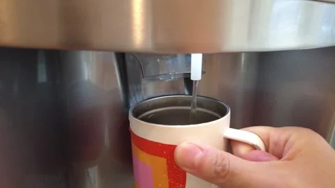 Quickly getting filtered water from the fridge water spout Stock Footage 246580729