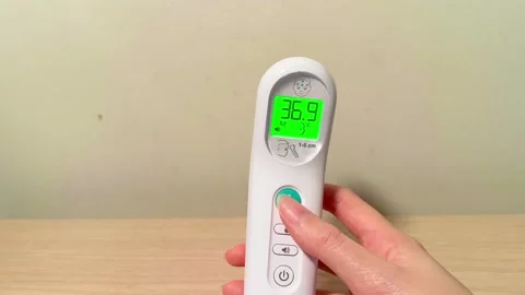 Quickly measure child's temperature with advanced digital forehead thermometer 動画素材 318610799