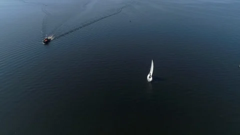 Quickly the Motor Boat Sails Up to the Sailing Yacht in Open Water. Air View. Ta Stock Footage 127775640
