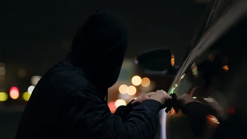 Quickly robber checking breaking entering alarm shines a flashlight in a car Vídeos de archivo 110888784