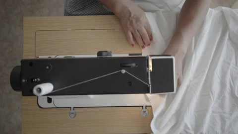 Quickly sewing a plain white bedsheet with machine Stock Footage 145504840