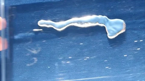 Quicksilver mercury close up mixed in trasparent box isolated on blue screen. Stock Footage 59856640