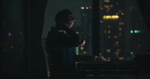 Quiet apartment night time mid adult person sits working at computer get tired Stock Footage 274652789