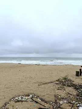 A quiet beach under dark storm clouds Stock Photos