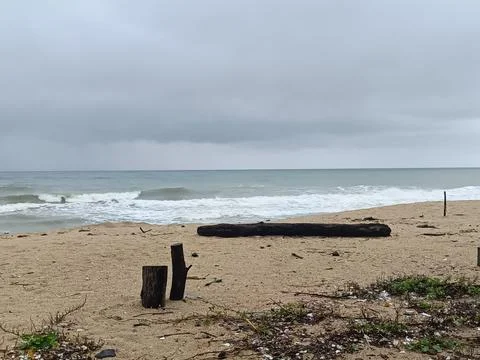 A quiet beach under dark storm clouds Stock Photos