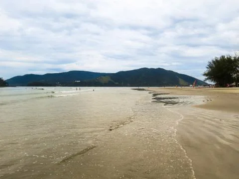 Quiet beach without waves with a wide strip of sand. Stock Photos