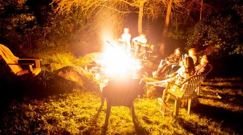 Quiet campfire surrounded by trees at night Stock Photos