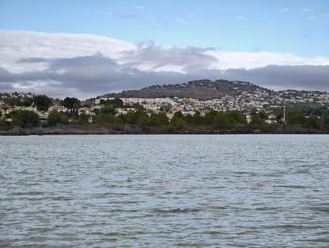 Quiet coast with distant mountain settlement, Tranquil waters surrounded by.. Фото
