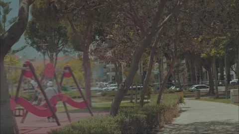 A quiet day in a city square with a playground and a winding walking path. Stock Footage 346708594