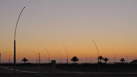 Quiet desert landscape before sunrise with empty roads, distant palm trees and Stock Footage 346244256