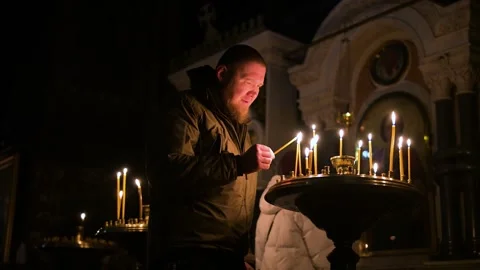 Quiet Devotion: A Man Lights a Prayer Candle in Kyiv's Historic St. Volodymyr's Stock-Footage 311616992