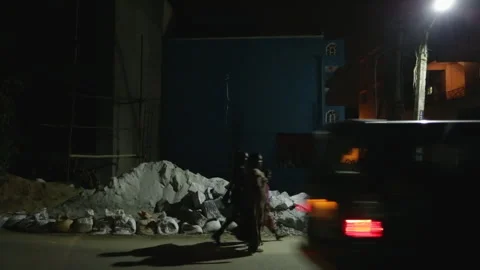 Quiet dim lighting late-night street scene with people walking passing car Vidéo 292887902