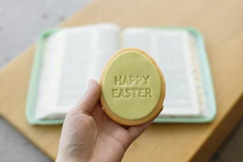 Quiet Easter moment with cookie and open Bible in natural light. Stock Photos