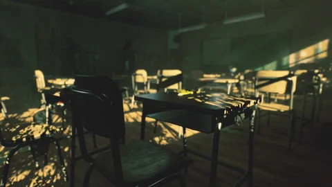 Quiet empty classroom filled with dust particles and faint glow of sunset Stock Footage 339794301