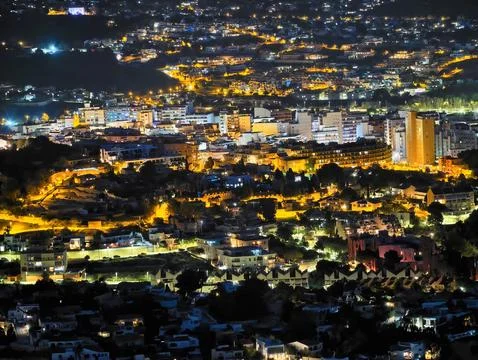 Quiet evening scene featuring densely built structures and illuminated stre.. Stock Photos