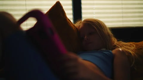 Quiet Evening - Young Girl Engaged with Tablet on Couch 库存影片 335425341