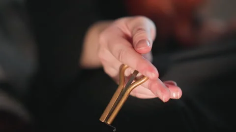 Quiet gesture with brass pendulum in dark atmosphere. Concentrated Caucasian 動画素材 346559500