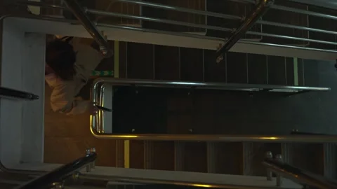 Quiet guest navigates dim hotel staircase with muted steps and glow 動画素材 335950502