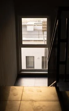 A quiet indoor perspective showing light streaming through a window onto a ti Stock Photos