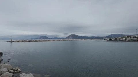 Quiet marina with breakwater and distant mountains in winter light Stock Footage 338109381
