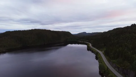 Quiet Norwegian Lake and Empty Highway under Cloudy Evening Sky Stock Footage 344324482