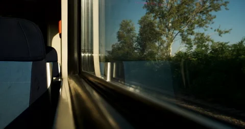Quiet passenger perspective from inside a train car looking out at green su.. Stock Footage 346278000