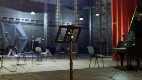 Quiet performance space with spotlight aiming at vacant seats and grand piano Stock Footage 340342127