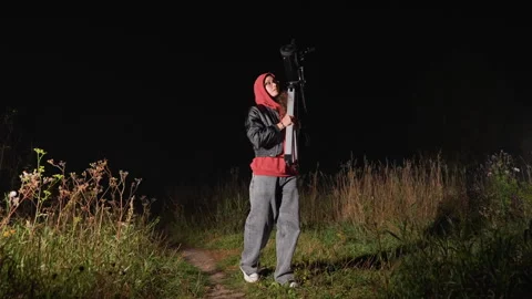 Quiet person arranges device for observing celestial bodies at night. Nighttime Stock Footage 331359272