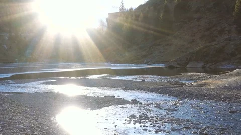 Quiet river in a valley between mountains in sunlight Stock Footage 71369977