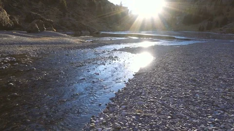 Quiet river in a valley between mountains in sunlight Stock Footage 71378320